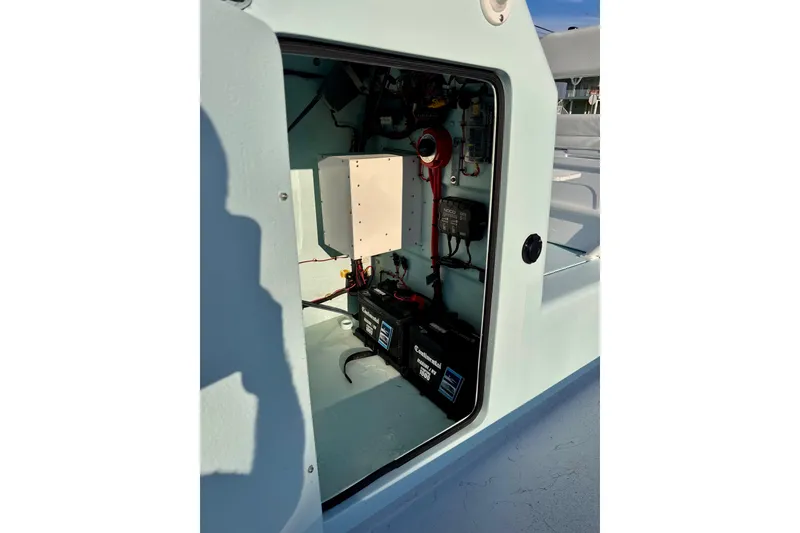 Slide: The Image of Interior view of Waterman Wildwater 23 boat's electrical compartment, showcasing batteries and wiring, 2023 model. - 22