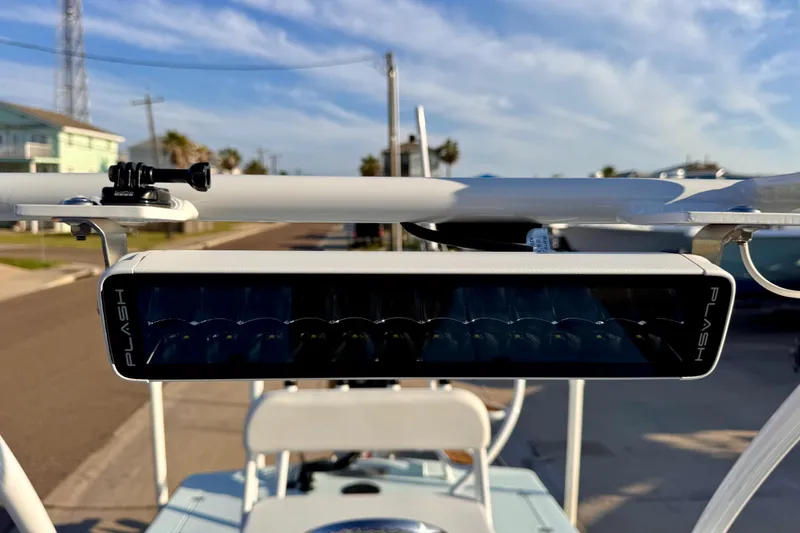Slide: The Image of Waterman Wildwater 23 boat with mounted Plash light bar, 2023 model, under clear blue sky. - 25