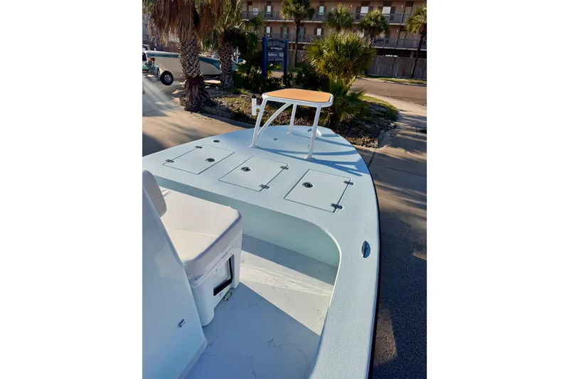 Slide: The Image of 2023 Waterman Wildwater 23 boat with seating and storage compartments, docked near palm trees. - 32