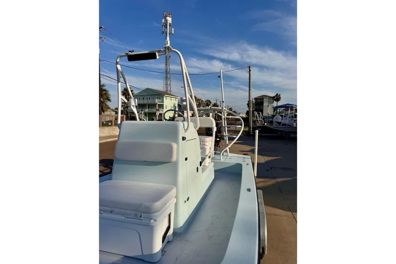 Slide: The Image of 2023 Waterman Wildwater 23 boat, light blue, parked outdoors under a clear sky. - 36