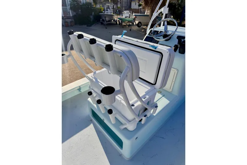 Slide: The Image of Open storage compartment on Waterman Wildwater 23 boat, showcasing rod holders and steering wheel. - 37