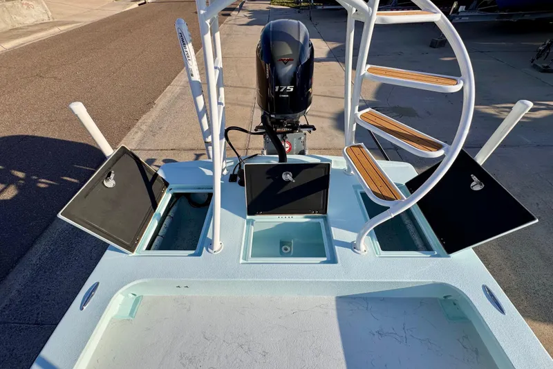 Slide: The Image of 2023 Waterman Wildwater 23 boat with open storage compartments and a 175 HP engine. - 41