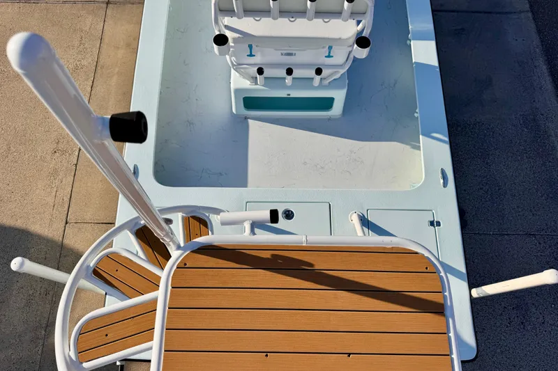 Slide: The Image of 2023 Waterman Wildwater 23 boat deck with wooden accents and fishing rod holders. - 44