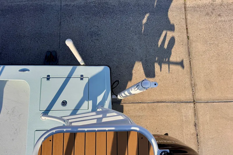 Slide: The Image of Overhead view of Waterman Wildwater 23 boat deck, 2023 model, with shadows on pavement. - 46