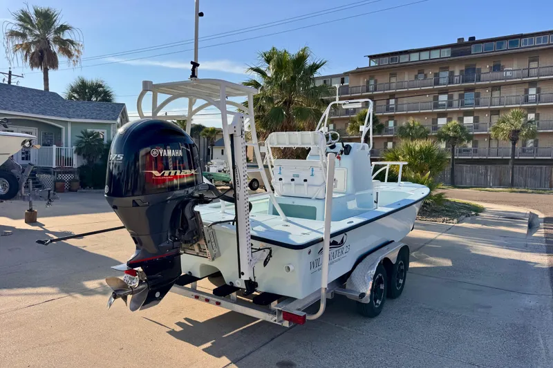 Slide: The Image of 2023 Waterman Wildwater 23 boat with Yamaha engine on trailer, parked in residential area. - 5