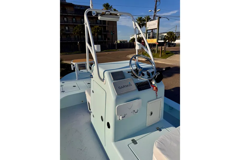 Slide: The Image of 2023 Waterman Wildwater 23 boat console with Garmin navigation system, steering wheel, and controls. - 8