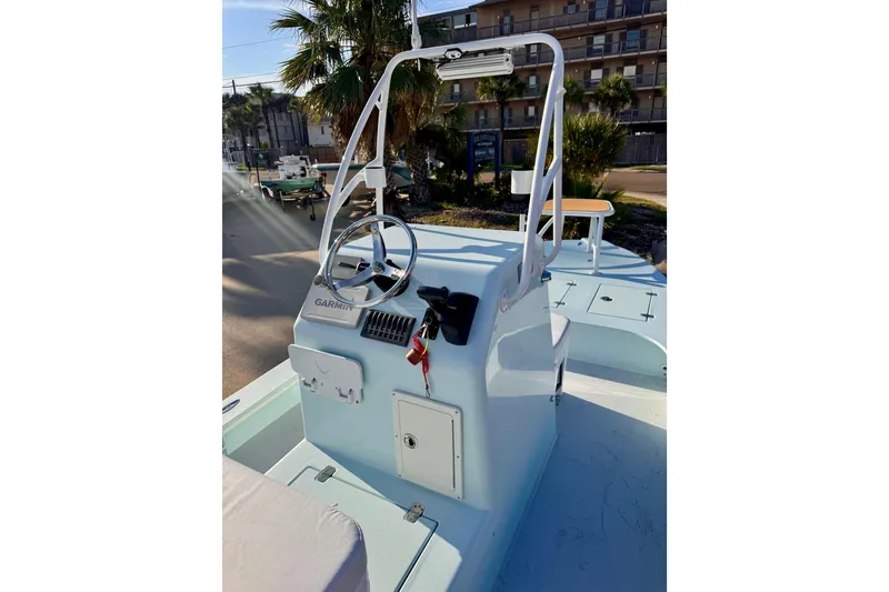 Slide: The Image of 2023 Waterman Wildwater 23 boat console with steering wheel and Garmin equipment, outdoor setting. - 9