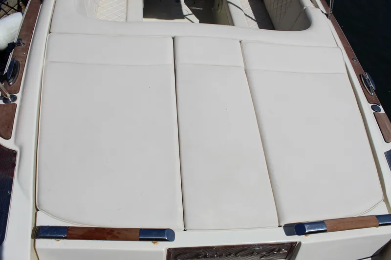 Slide: The Image of 2022 Chris-Craft Launch 27 boat with white cushioned seating and wooden accents. - 10