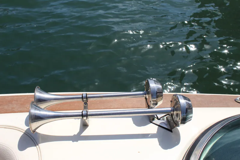 Slide: The Image of 2022 Chris-Craft Launch 27 boat horns on deck, reflecting sunlight over water. - 15