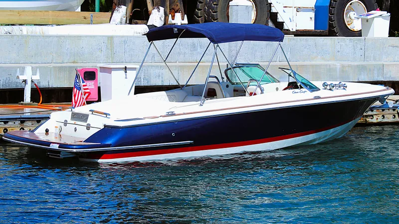 Slide: The Image of 2022 Chris-Craft Launch 27 boat docked with blue canopy and American flag. - 2