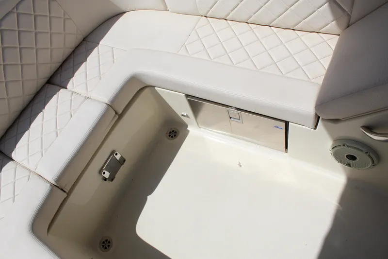 Slide: The Image of 2022 Chris-Craft Launch 27 interior seating with diamond-stitched upholstery and storage compartment. - 22