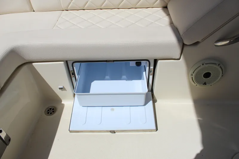 Slide: The Image of 2022 Chris-Craft Launch 27 boat interior with open storage compartment and cushioned seating. - 23