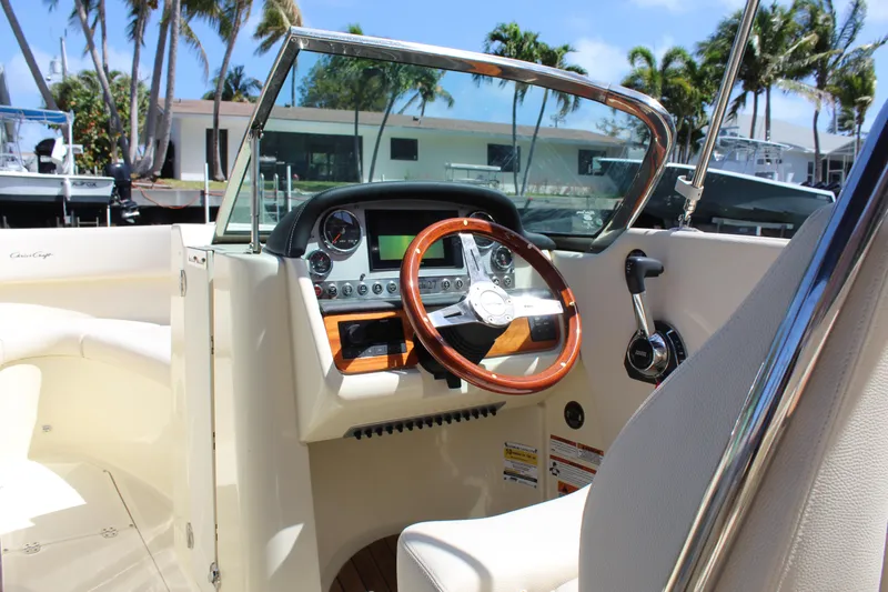 Slide: The Image of 2022 Chris-Craft Launch 27 boat dashboard with wooden steering wheel and modern controls. - 26