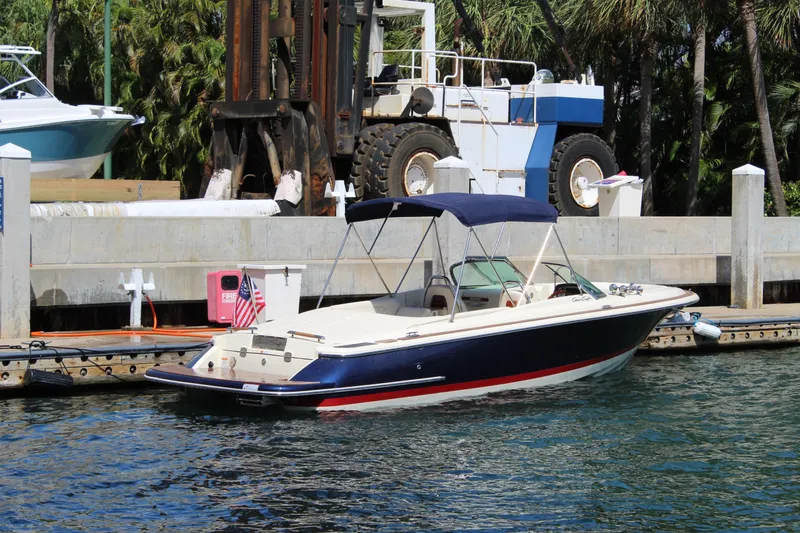 Slide: The Image of 2022 Chris-Craft Launch 27 boat docked in marina, featuring sleek design and navy blue hull. - 29