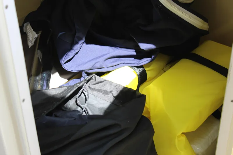 Slide: The Image of Storage compartment with clothing and gear on a 2022 Chris-Craft Launch 27 boat. - 36