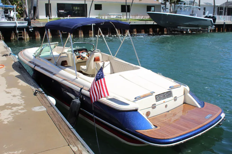 Slide: The Image of 2022 Chris-Craft Launch 27 boat docked, featuring elegant design and American flag. - 4