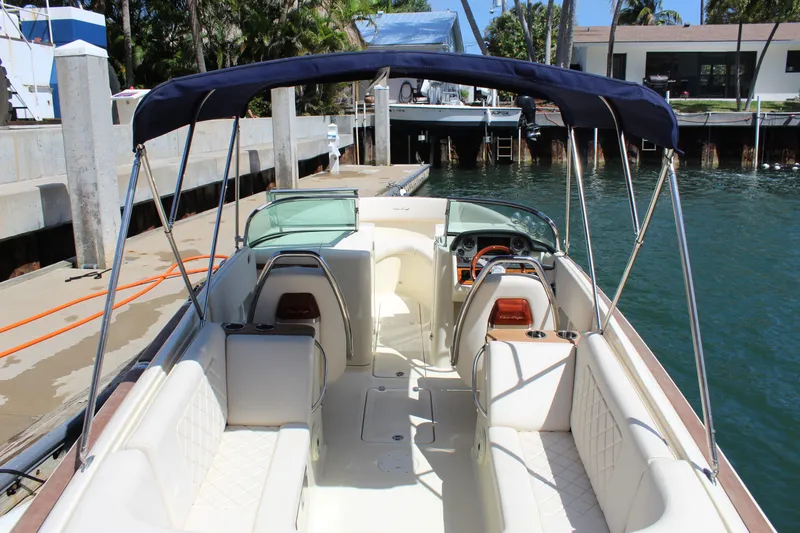 Slide: The Image of 2022 Chris-Craft Launch 27 boat with canopy, docked in a marina. - 5