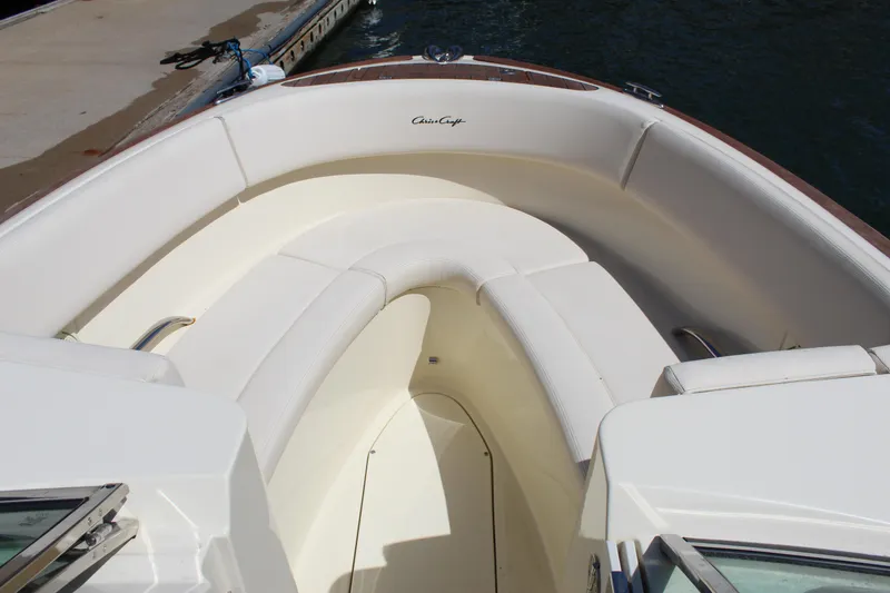Slide: The Image of 2022 Chris-Craft Launch 27 boat interior with white seating, dockside view. - 9