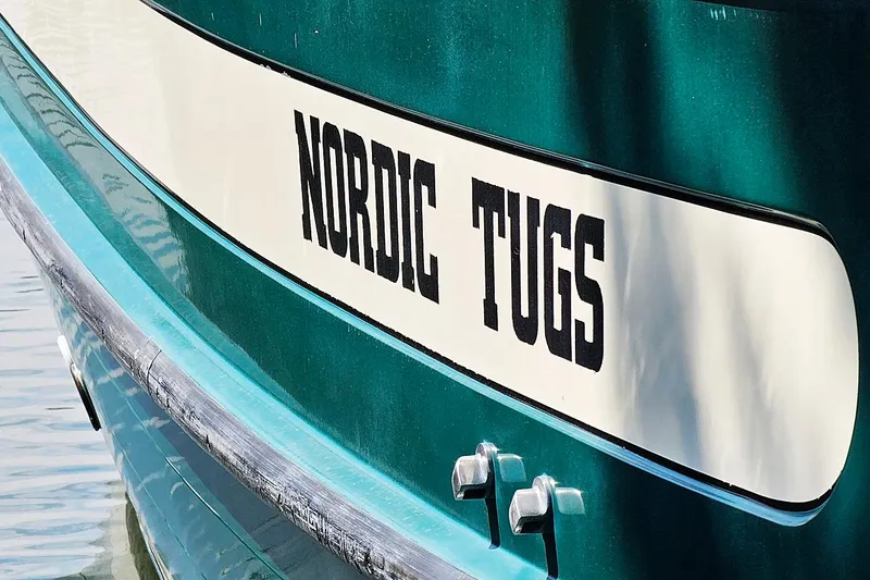 The Image of 1996 Nordic Tug 26 docked at marina, featuring green and white exterior. - 0