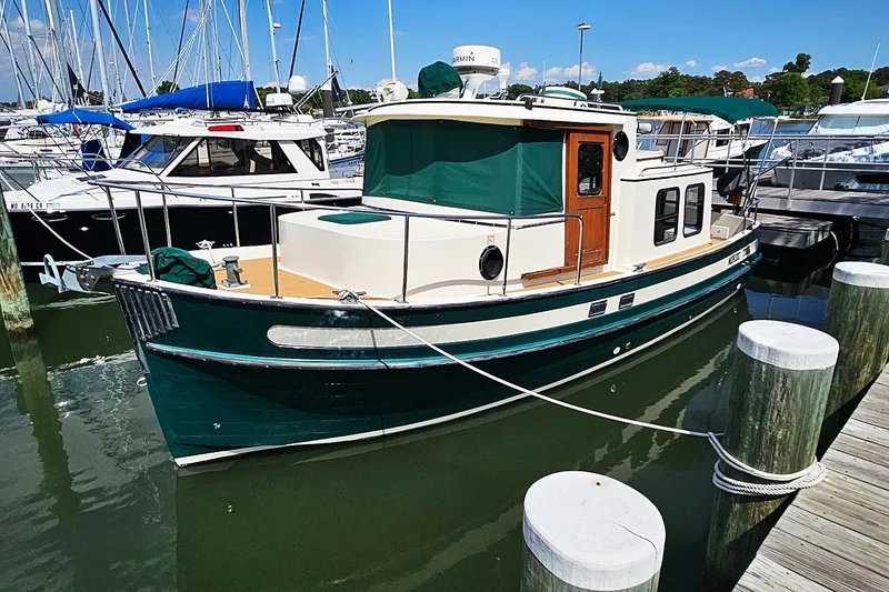 Slide: The Image of 1996 Nordic Tug 26 boat with bold lettering on the hull. - 1