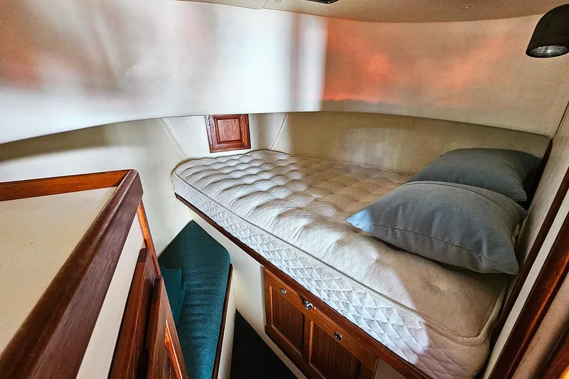 Slide: The Image of Cozy cabin interior of a 1996 Nordic Tug 26 with a comfortable bed and pillows. - 16