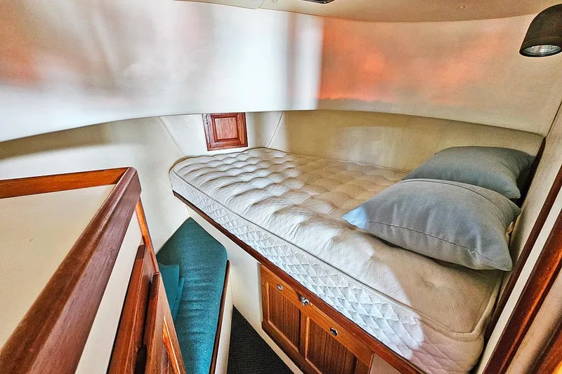 Slide: The Image of Cozy cabin interior of a 1996 Nordic Tug 26 with a comfortable bed and wooden accents. - 17