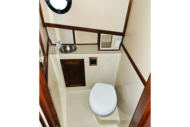Slide: The Image of Compact bathroom in a 1996 Nordic Tug 26, featuring a toilet and sink. - 18
