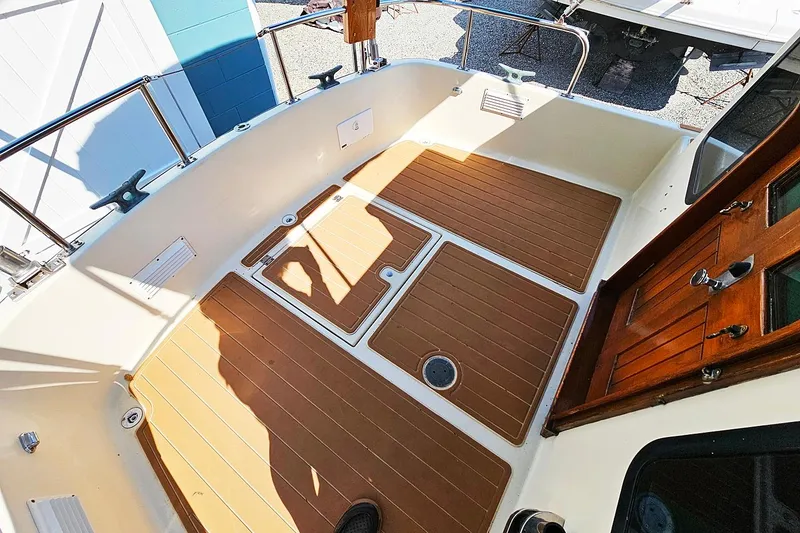 Slide: The Image of 1996 Nordic Tug 26 boat deck with wooden flooring and metal railings. - 4
