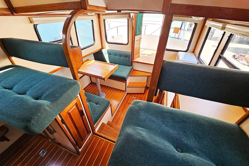 Slide: The Image of Interior of a 1996 Nordic Tug 26 with green upholstery and wooden accents. - 9