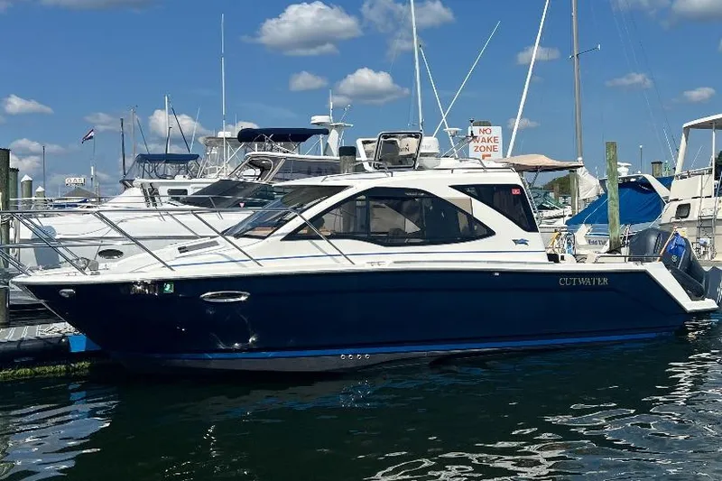 The Image of 2016 Cutwater C-24 boat docked at marina under blue sky. - 0