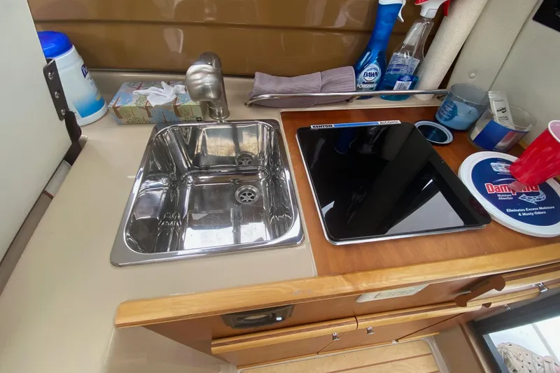 Slide: The Image of 2016 Cutwater C-24 galley with stainless steel sink and electric cooktop. - 15