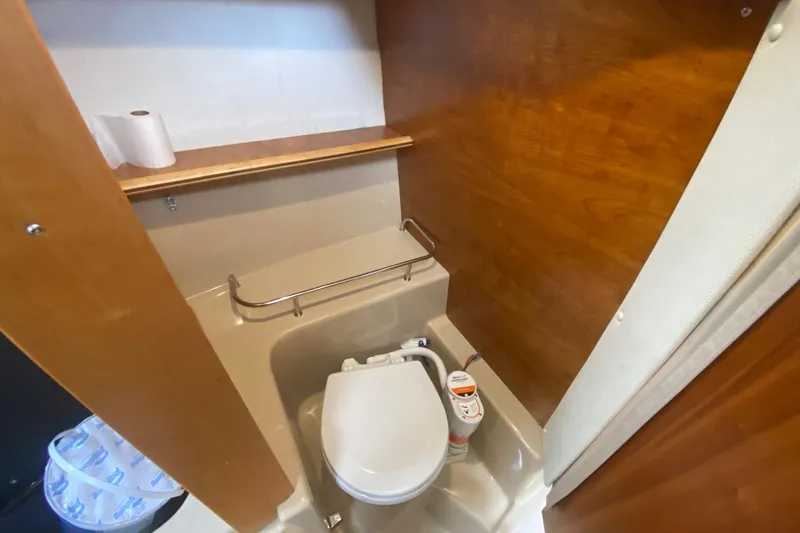Slide: The Image of Compact bathroom in 2016 Cutwater C-24 boat with toilet and wooden paneling. - 20