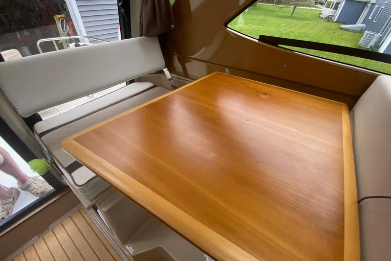Slide: The Image of Interior of 2016 Cutwater C-24 boat with wooden table and cushioned seating. - 22