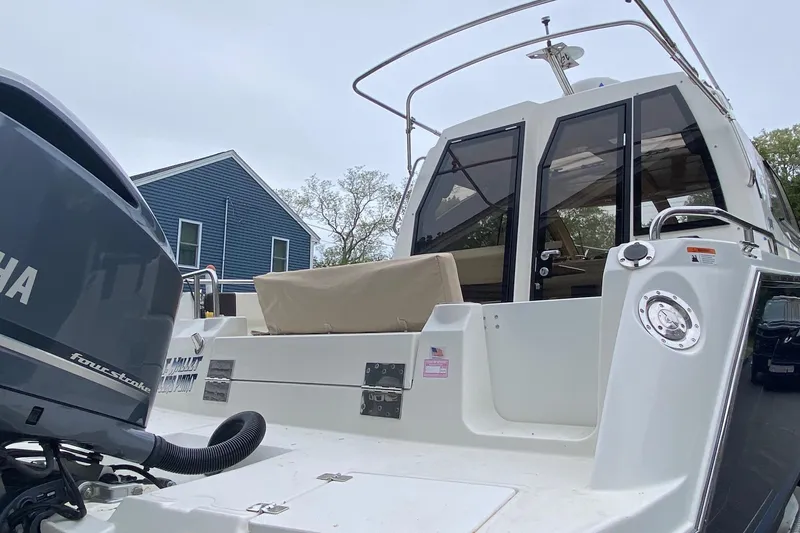 Slide: The Image of 2016 Cutwater C-24 boat with Yamaha outboard motor, docked near a blue house. - 24