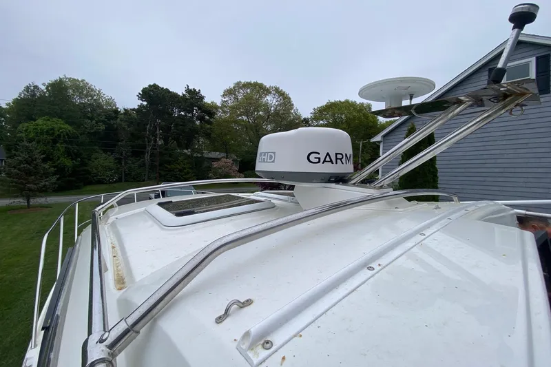 Slide: The Image of 2016 Cutwater C-24 boat with Garmin radar, docked near a house and trees. - 29