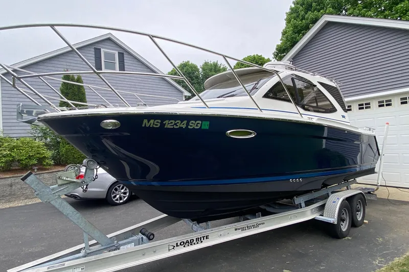 Slide: The Image of 2016 Cutwater C-24 boat on trailer, parked in driveway near house. - 3