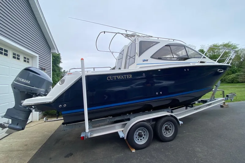 Slide: The Image of 2016 Cutwater C-24 boat on trailer with Yamaha outboard motor, parked near garage. - 4
