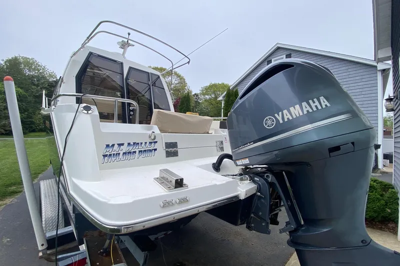 Slide: The Image of 2016 Cutwater C-24 boat with Yamaha outboard motor, parked near a house. - 6