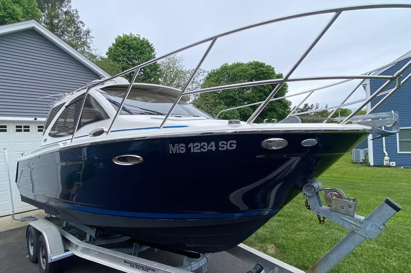 Slide: The Image of 2016 Cutwater C-24 boat on trailer, parked near a house with green lawn. - 8