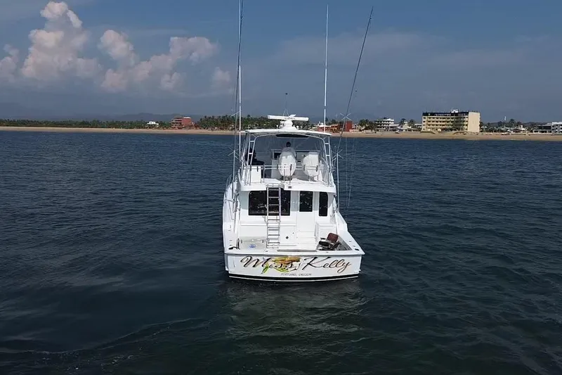 Slide: The Image of 2001 Hatteras 55 Convertible yacht on calm waters near a coastal city. - 2