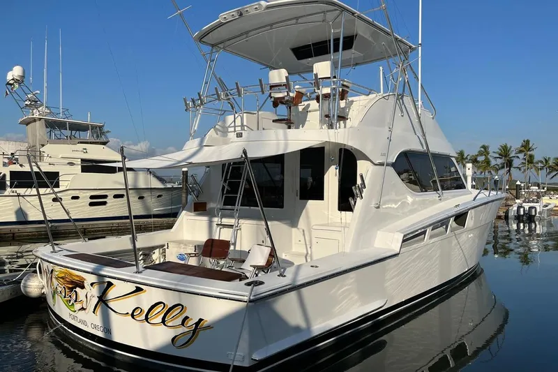 Slide: The Image of 2001 Hatteras 55 Convertible yacht docked, featuring a spacious deck and elegant design. - 4