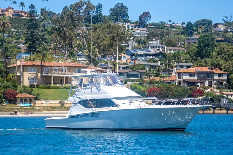 Slide: The Image of 2001 Hatteras 55 Convertible yacht cruising near luxurious waterfront homes. - 4