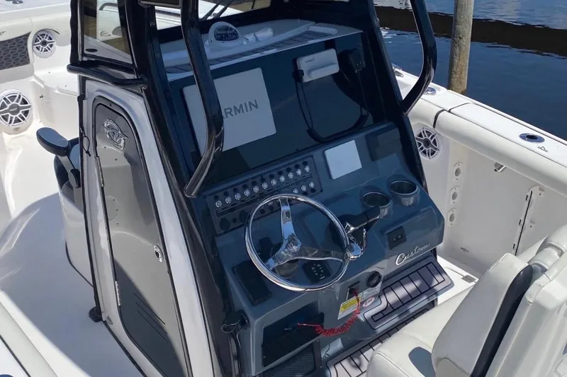 Slide: The Image of 2024 Tidewater 256 CC Adventure boat console with steering wheel and Garmin display. - 4