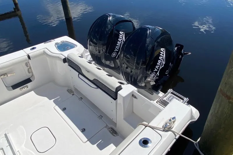 Slide: The Image of 2024 Tidewater 256 CC Adventure boat with dual Yamaha engines docked by the water. - 5