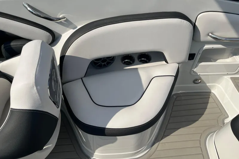 Slide: The Image of 2025 Crownline Eclipse E235 boat interior with white and black seating, featuring cup holders. - 12