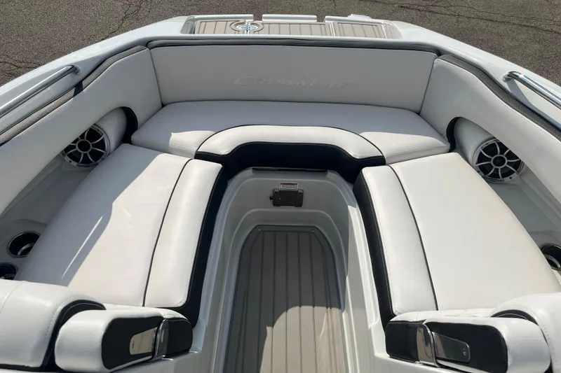 Slide: The Image of 2025 Crownline Eclipse E235 boat interior with white cushioned seating and built-in speakers. - 23