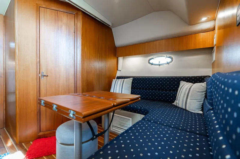 Slide: The Image of Interior of 1998 Tiara Yachts 3500 Express with cozy seating and wooden accents. - 10