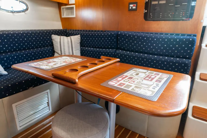 Slide: The Image of Interior of 1998 Tiara Yachts 3500 Express with wooden table and blue seating. - 11