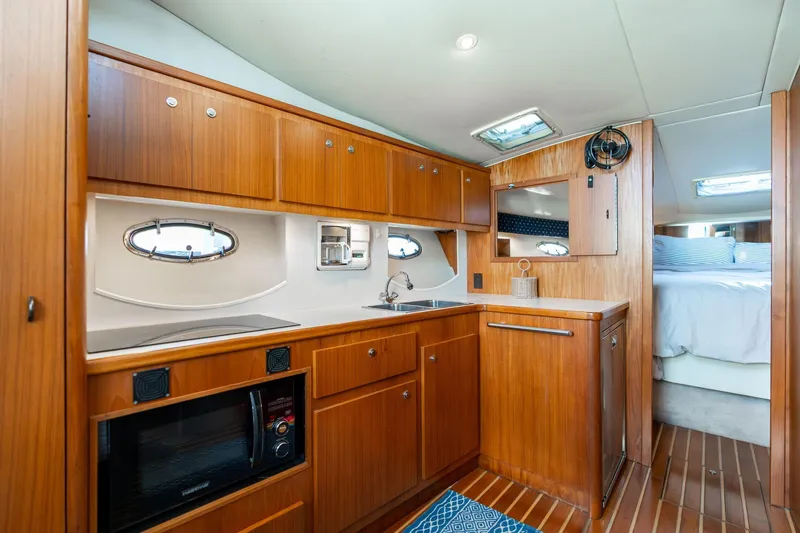 Slide: The Image of 1998 Tiara Yachts 3500 Express interior kitchen with wood cabinetry and modern appliances. - 13