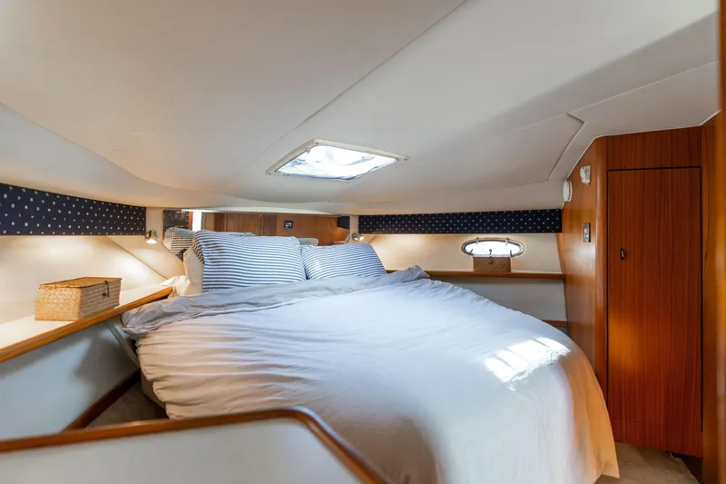 Slide: The Image of Cozy cabin interior of 1998 Tiara Yachts 3500 Express with bed and wooden accents. - 17